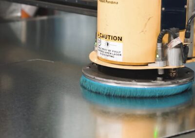 Industrial floor polisher with a blue brush head smoothing a metal surface, yellow housing labeled CAUTION.